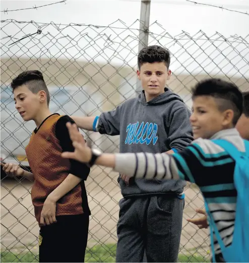  ?? PHOTOS: MAYA ALLERUZZO / THE ASSOCIATED PRESS ?? Ahmed Ameen Koro, centre, talks with other children in the Esyan Camp for internally displaced people in Dahuk