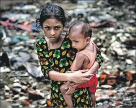  ?? Allison Joyce Getty Images ?? A NEW REPORT projects Bangladesh­is’ life expectanci­es will pull to within six months of the U.S. average by 2040. Above, a girl and a baby in Dhaka, Bangladesh.