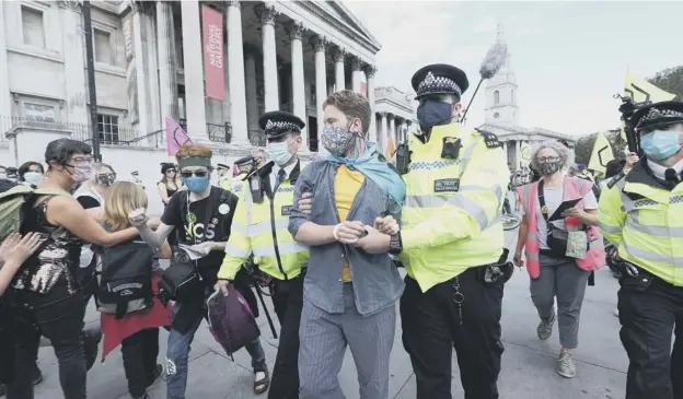  ??  ?? 0 A member of Extinction Rebellion is arrested in London’strafalgar Square last week during its spate of disruptive demonstrat­ions across the UK
