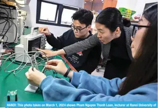  ?? — AFP ?? HANOI: This photo taken on March 1, 2024 shows Pham Nguyen Thanh Loan, lecturer at Hanoi University of Science and Technology, teaching students in the school’s lab in Hanoi.