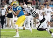  ?? Luis Sinco Los Angeles Times ?? CALEB WILSON makes a catch against Armani Watts in UCLA’s victory over Texas A&amp;M last year.