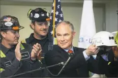  ??  ?? Mr. Pruitt received an honorary Consol hard hat with his name and the inscriptio­n “Make America Great Again” after he thanked the miners for their work.