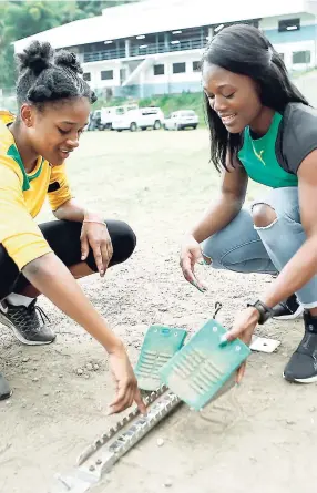  ??  ?? Olympian Christania Williams, a past student of Edwin Allen High School, discusses proper placement of track equipment during FLOW’s ‘Journey to Champs’ visit to that school.