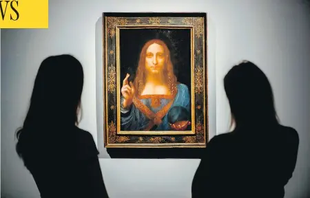  ?? TOLGA AKMEN / AFP / GETTY IMAGES ?? Christie’s employees pose in front of a painting entitled Salvator Mundi by Italian artist Leonardo da Vinci at Christie’s auction house in central London in October. It sold on Wednesday for more than US$450 million, a new record for a painting at...