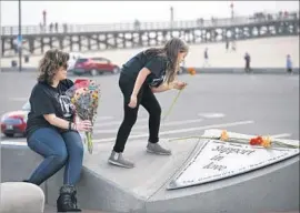  ?? Glenn Koenig Los Angeles Times ?? CHRISTINA STRETZ and her daughter Anabella, 9, visit a memorial in Seal Beach. Some victims’ relatives believed that closure could be found in a plea deal.