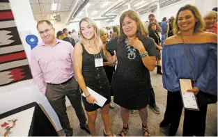  ?? LUIS SÁNCHEZ SATURNO/THE NEW MEXICAN ?? Hortencia Torres, inside right, reacts Friday night as she learns that her granddaugh­ter, Mai Ly Torres, inside left, won first place in the youth retablos category.