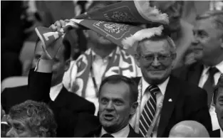  ??  ?? POLISH PRIME Minister Donald Tusk waves a soccer scarf before a Euro 2012 match.