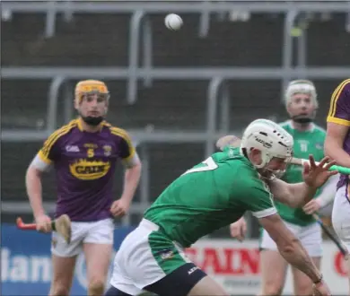  ??  ?? Top scorer Conor McDonald delivers the ball despite the blocking attempt by Limerick defender Seamus Hickey.