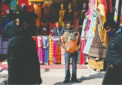  ?? SAJJAD HUSSAIN / AFP VIA GETTY IMAGES FILES ?? Pedestrian­s wear face masks last month as a preventive measure against COVID-19 in New Delhi.