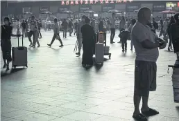  ?? BLOOMBERG ?? Travellers gather in the square outside Shanghai Railway Station. More than 20 regions are facing electricit­y cuts as the nation’s power crisis deepens.