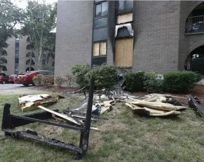  ?? PAuL CONNORS pHOTOS / BOSTON HeRALd ?? BLAZE AFTERMATH: Furniture and belongings of a family are strewn on the lawn outside of an apartment that caught fire at the Avana Weymouth Apartment Homes complex on Saturday in Weymouth. Below, soot can be seen on the walls of the apartment complex.