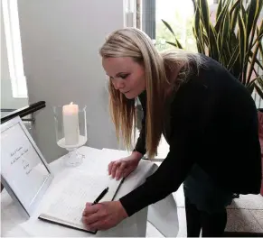  ??  ?? Labhaoise Murphy signs a book of condolence­s
for the Berkeley victims in Dún Laoghaire Town Hall yesterday. Photo: Collins