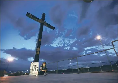  ?? Christian Chavez Associated Press ?? A WOMAN in Juarez, Mexico, visits a vigil for the victims of Saturday’s mass shooting in nearby El Paso. Seven Mexican citizens died.