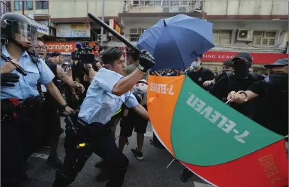  ?? FOTO: KIN CHEUNG/AP ?? En polis går till attack mot demonstran­ter i Hongkong under gårdagens protester.