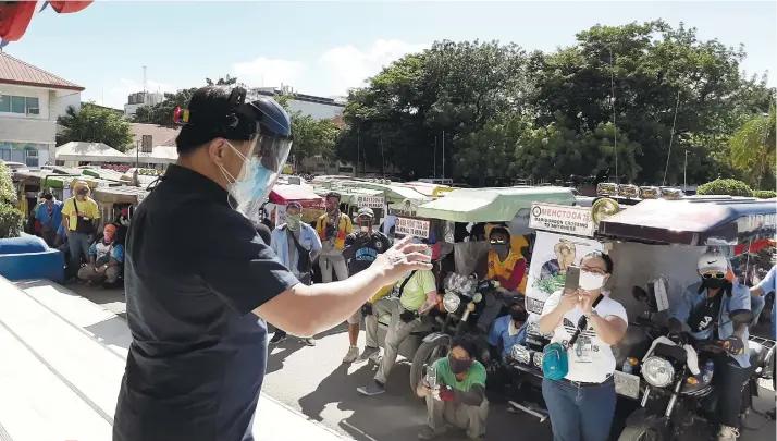  ?? LAPU-LAPU CITY PUBLIC INFORMATIO­N OFFICE ?? TAPPING TRICYCLE DRIVERS. Lapu-Lapu City Mayor Junard Chan speaks to tricycle drivers in his city concerning the launching of his Rekovida (Rekorida Kontra Virus sa Dakbayan) program. The Rekovida program aims to tap the services of tricycle drivers to help remind Lapu-Lapu City residents to follow quarantine protocol such as wearing masks at all times and always bringing their quarantine passes while outside their homes to protect themselves from being infected with the coronaviru­s. Around 80 tricycle drivers have participat­ed in the program. /