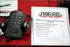  ?? DAVID ZALUBOWSKI — THE ASSOCIATED PRESS FILE ?? A playbook sits next to a telephone set up in the NORAD Tracks Santa center at Peterson Air Force Base in Colorado Springs, Colo., in 2019. The North American Aerospace Defense Command has announced that NORAD will track Santa on Dec. 24, just as it has done for 65 years.