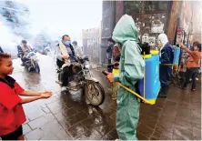  ?? AFP ?? A Yemeni municipal worker sprays disinfecta­nt in a market in Sanaa.