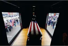  ?? AP PHOTO/DAVID J. PHILLIP, POOL ?? THE FLAG-DRAPED CASKET OF FORMER President George H.W. Bush passes through Magnolia, Texas, on Thursday along the train route from Spring to College Station, Texas.