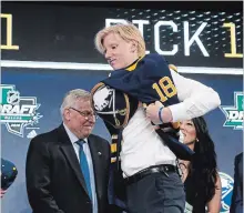  ?? MICHAEL AINSWORTH THE ASSOCIATED PRESS ?? Rasmus Dahlin puts on a jersey after being selected by the Buffalo Sabres first overall in Friday’s NHL draft.