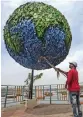  ?? — PTI ?? A replica of earth being cleaned by a worker on the banks of upper lake in Bhopal on Thursday. The Earth Day is being observed to demonstrat­e support to environmen­tal protection for the theme “Restore Our Earth”.