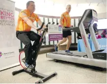  ?? LEAH HENNEL ?? Mike Reid, left, and Joel Guay take part in an event Friday at the Tom Baker Cancer Centre in support of World Cancer Day.