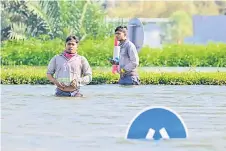  ?? ?? People wade across a flooded street in Dubai following heavy rains.