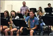  ?? NWA Democrat-Gazette/DAVID PEROZEK ?? Philip Shewmaker, the jazz band director at Bentonvill­e High School, works Thursday with students. The Bentonvill­e High School jazz band is re-emerging after an extended layoff following the death of the band’s director, Zach Roddy, five years ago.