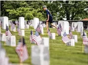  ?? BRANDEN CAMP / SPECIAL ?? American flags are seen in front headstones as a young boy walks through Marietta National Cemetery ahead of Memorial Day, Saturday in Marietta.