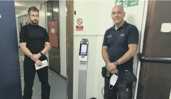  ??  ?? Custody Sergeant Graham Clifton and Chris Christophi of Ace4cctv with the thermal imaging scanner at Peterborou­gh’s Thorpe Wood Police Station.