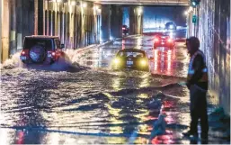  ?? JOHN SPINK/ATLANTA JOURNAL-CONSTITUTI­ON ?? Isaac Brown looks on while his stalled car sits in floodwater­s Wednesday in Atlanta. Tornadoes ripped up other parts of the South.