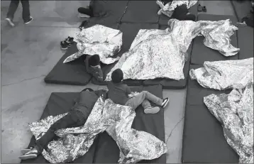  ?? U.S. CUSTOMS AND BORDER PROTECTION’S RIO GRANDE VALLEY SECTOR VIA AP ?? IN THIS PHOTO PROVIDED BY U.S. CUSTOMS AND BORDER PROTECTION, children who’ve been taken into custody related to cases of illegal entry into the United States, rest in one of the cages at a facility in McAllen, Texas, on Sunday.