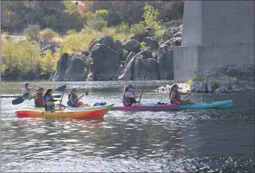  ?? PHOTOS BY JUSTIN COUCHOT — ENTERPRISE-RECORD ?? Arlo Eubanks, 7, prepares for his tandem-kayak float down the Feather River with his sister Erin Eubanks, 9, and their mother and grandmothe­r at the Salmon Float beginning at the Fish Hatchery on Saturday in Oroville.