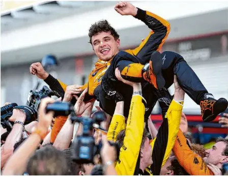  ?? Foto: R. Blackwell/dpa ?? Frenetisch gefeiert beim Premierens­ieg: der britische Mclaren-pilot Lando Norris.