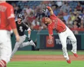  ?? MARCIO JOSE SANCHEZ/AP ?? Angels shortstop Wilfredo Tovar, right, catches an infield fly ball from the White Sox's Yolmer Sanchez during the third inning Thursday in Anaheim, Calif.