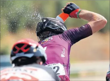  ??  ?? Jetse Bol, ciclista del Burgos, se tira un bidón de agua por la cabeza durante el día de ayer.