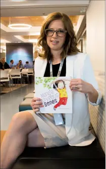  ?? Herald photo by Greg Bobinec ?? Orthopedic Surgeon Dr. Carrie Kollias with her new children’s book “Maria’s Marvelous Bones,” which helps children understand the different rolls and devices used when visiting the hospital for an injury.