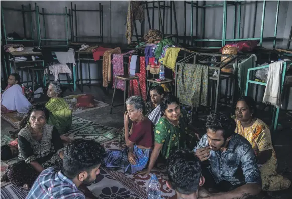  ?? Getty ?? Residents from villages surroundin­g Chengannur take shelter at a relief camp set up near a college in the town