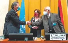  ?? AFP ?? Heads of the LNA and GNA delegation­s Mohammad Al Amami ( left) and Ahmad Ali Abu Shahma shake hands after signing the agreement as Stephanie Williams looks on in Geneva.