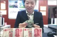  ?? ZHANG YUN / CHINA NEWS SERVICE ?? An employee counts cash at a bank in Taiyuan, capital of Shanxi province.