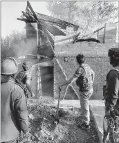  ??  ?? Security forces personnel dousing the fire at a slain PDP leader's house in Srinagar on Tuesday.