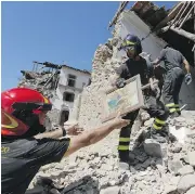  ?? ANDREW MEDICHINI / THE ASSOCIATED PRESS ?? Firefighte­rs retrieve a painting from a church in the small town of Rio, near Amatrice, central Italy, which was hit by a devastatin­g earthquake last week.