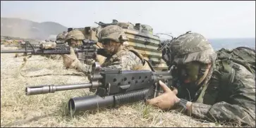  ?? The Associated Press ?? TRAINING EXERCISES: In this March 30, 2015, file photo, marines of South Korea, right, and the U.S aim their weapons near amphibious assault vehicles during U.S.-South Korea joint landing military exercises as part of the annual joint military exercise...