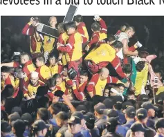  ?? — Reuters photo ?? Devotees climb on a carriage to hold the Black Nazarene during an annual procession in Rizal park, metro Manila, Philippine­s.