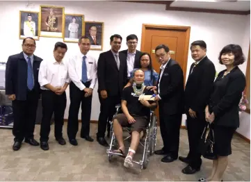  ??  ?? Chong (third right) presents the cheque to Lobbie, witnessed by Mordi (fourth left), David (second left), King Wei (fifth left), Chang (right), Dr Ting (second right), Phillip (third left) and others.