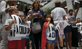  ??  ?? Areva Gopal, 3, of Arlington, Va. (center) attends a protest of families asking for the reunificat­ion of immigrant families who were separated at the border, Thursday, on Capitol Hill in Washington. AP PHOTO/JACQUELYN MARTIN