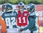  ?? CHRIS SZAGOLA — THE ASSOCIATED PRESS ?? Eagles quarterbac­k Carson Wentz, center, throws the ball to wide receiver John Hightower, left, during a practice. Hightower, a rookie, went to high school five minutes from Washington’s stadium.