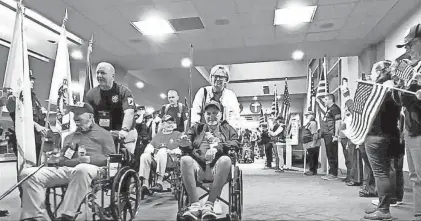  ?? PROVIDED BY THE RI FIRE CHIEFS ASSOCIATIO­N ?? Veterans move past a Fire Department honor guard and well-wishers at Rhode Island Internatio­nal T.F. Green Airport on an early morning in June, en route to their flight to Washington, D.C.