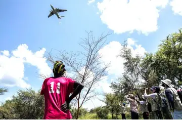  ??  ?? People watch as a plane air drops UN’s World Food Programme food aid near the town of Katdalok. — Reuters photo