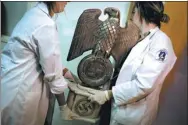  ?? NATACHA PISARENKO / ASSOCIATED PRESS ?? Members of the federal police carry a Nazi statue at the Interpol headquarte­rs in Buenos Aires, Argentina.