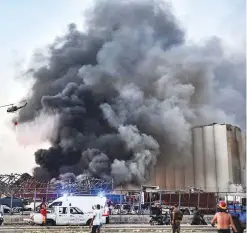  ?? AFP ?? A helicopter puts out a fire at the blast scene. The disaster may have started with a fire at a warehouse, state-run media said.